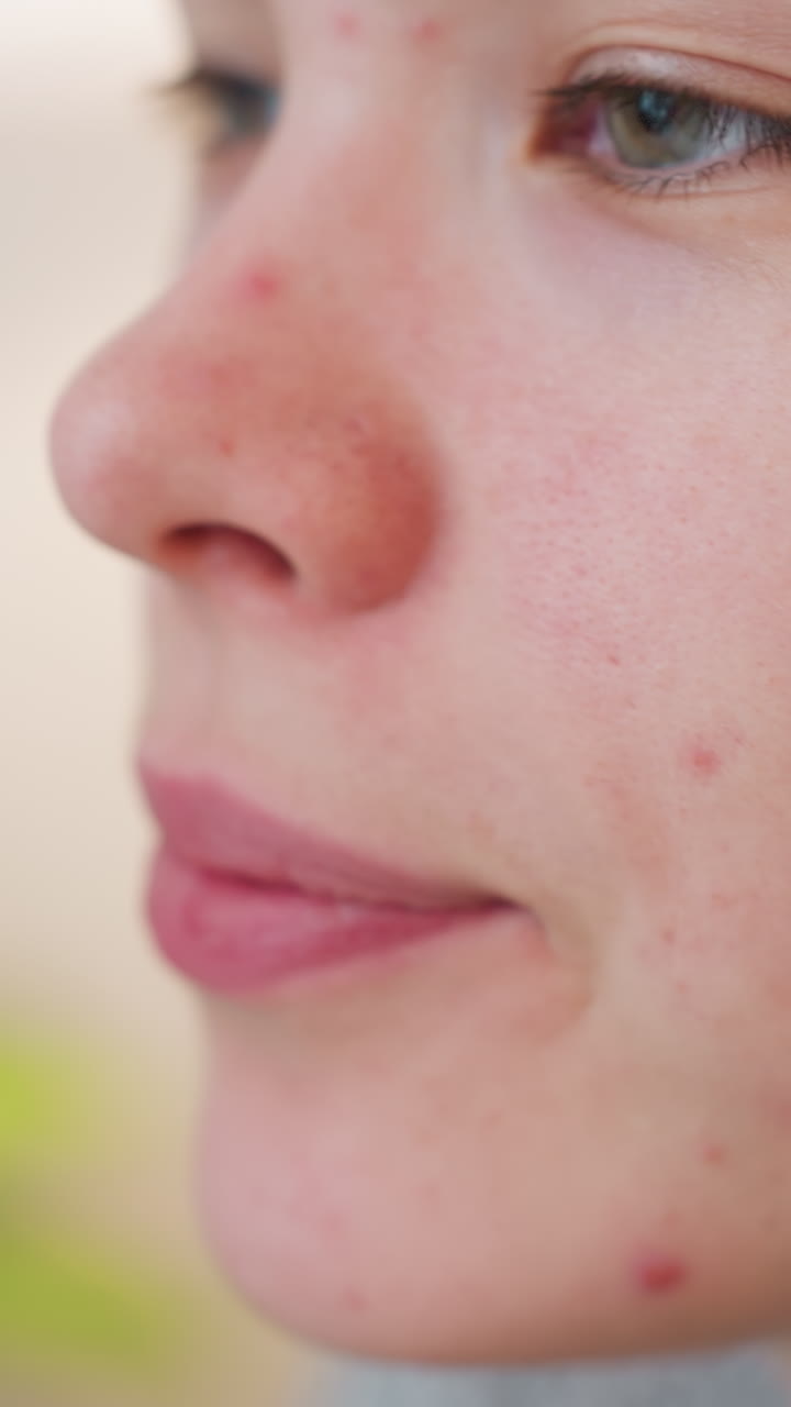Primo piano di un'adolescente caucasica che sorseggia da una tazza nella morbida luce del mattino, acne e lentiggini visibili, occhi chiusi delicatamente, inalazione tranquilla, tazza di ceramica vicino alle labbra, texture naturale della pelle, ritratto spontaneo