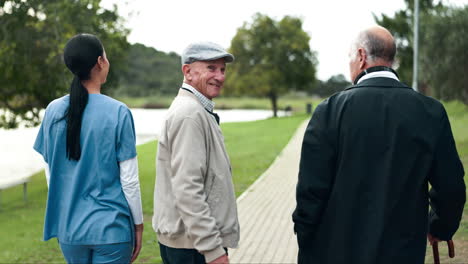 Seniors walking in park with caregiver