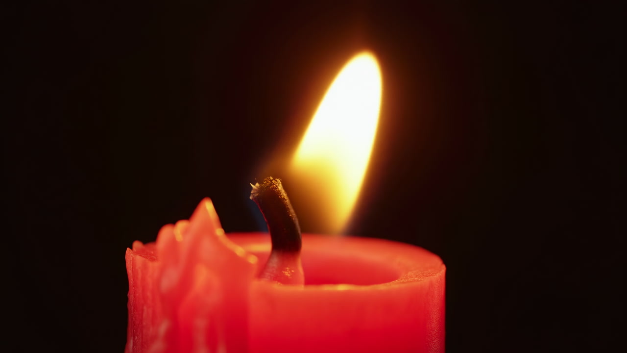 Red Candle Flame Closeup Warm Glow Melting Wax And Charred Wick With Amber Flame Flicker Against Black