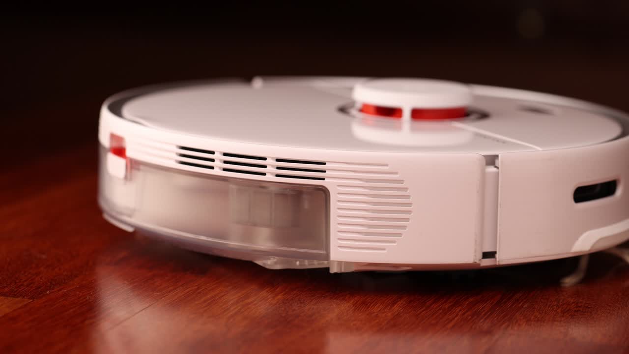 나무 바닥에 리더를 가진 스마트 로 진공청소기 로 진소기는 아파트의 자동 청소를 수행합니다. 느린 동작 100fps.