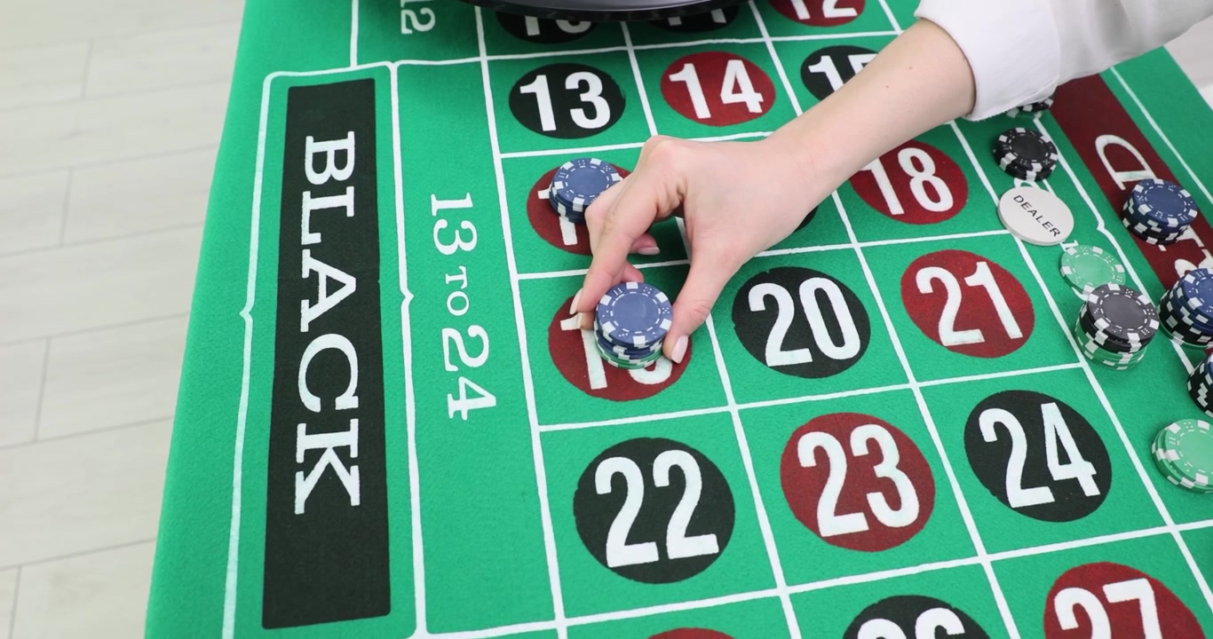 Il croupier del casinò posiziona le fiches da gioco sul tavolo verde della roulette