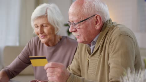 elderly couple making online payment using credit card and laptop computer 1