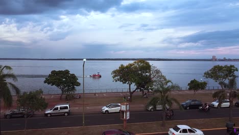 Aerial-view-of-seaside-road-with-cars-and-bikers-in-Posadas,-Misiones,-Argentina