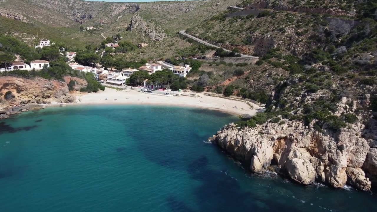 Vista aerea che svela la cala della Granadella con un paio di piccole imbarcazioni vicine. Javea, Spagna.