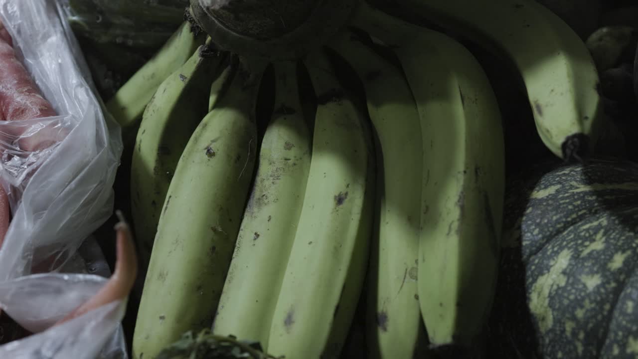 plátano fresco sin madurar en la tienda de verduras para la venta por la noche