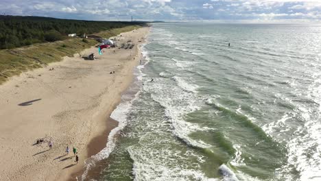 Antenne:-Menschen,-Die-An-Einem-Strand-Spazieren-Gehen,-Während-Surfer-Am-Ostseestrand-Surfen