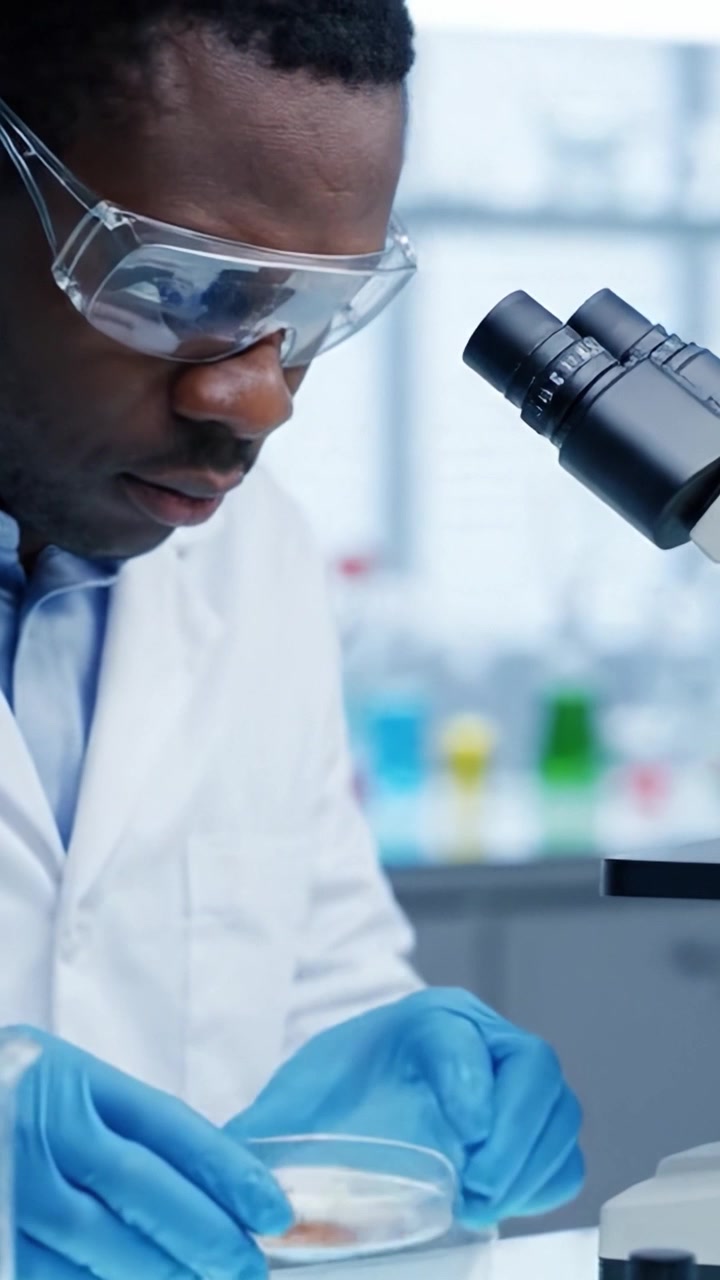 Uno scienziato dedicato esamina meticolosamente campioni sotto un microscopio in un laboratorio, evidenziando l'importanza della precisione e della ricerca nell'esplorazione scientifica.