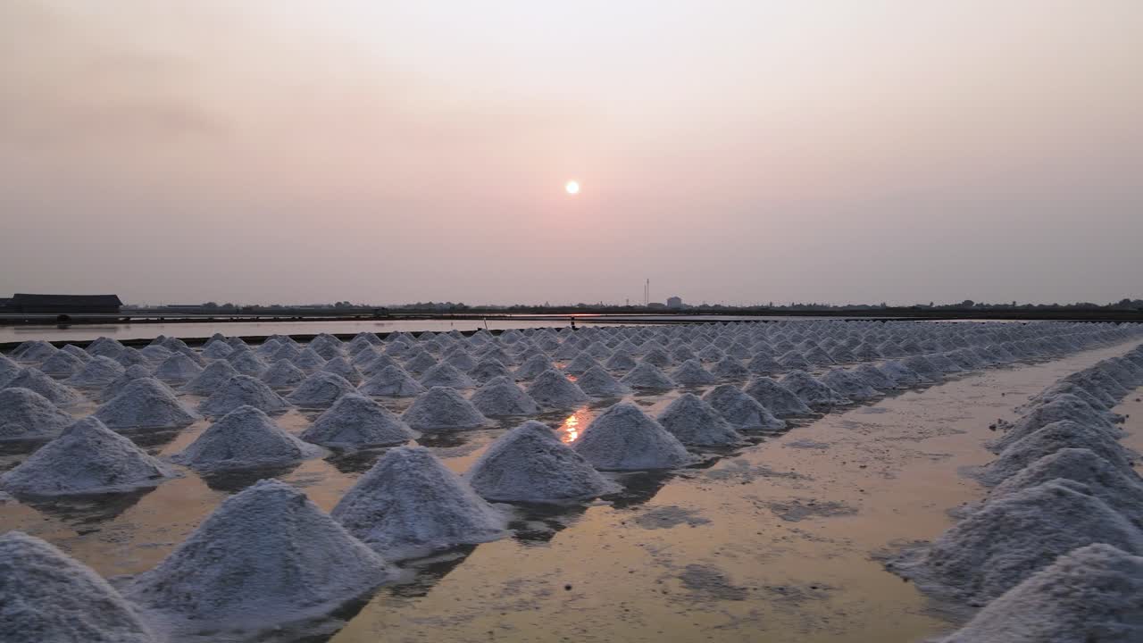 Atardecer en Tailandia con montones de sal marina listos para su recolección.