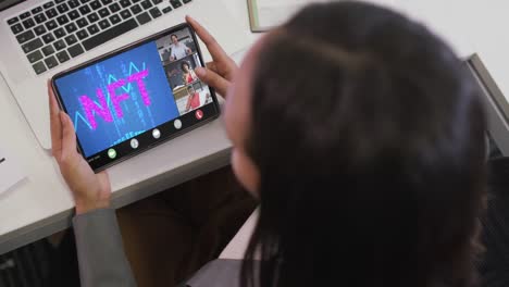 biracial businesswoman using tablet for video call with diverse business colleagues
