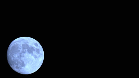 lapso de tiempo de luna llena, elevándose en el oscuro cielo nocturno