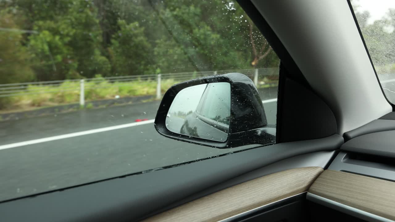 vista del espejo lateral del coche en un camino mojado