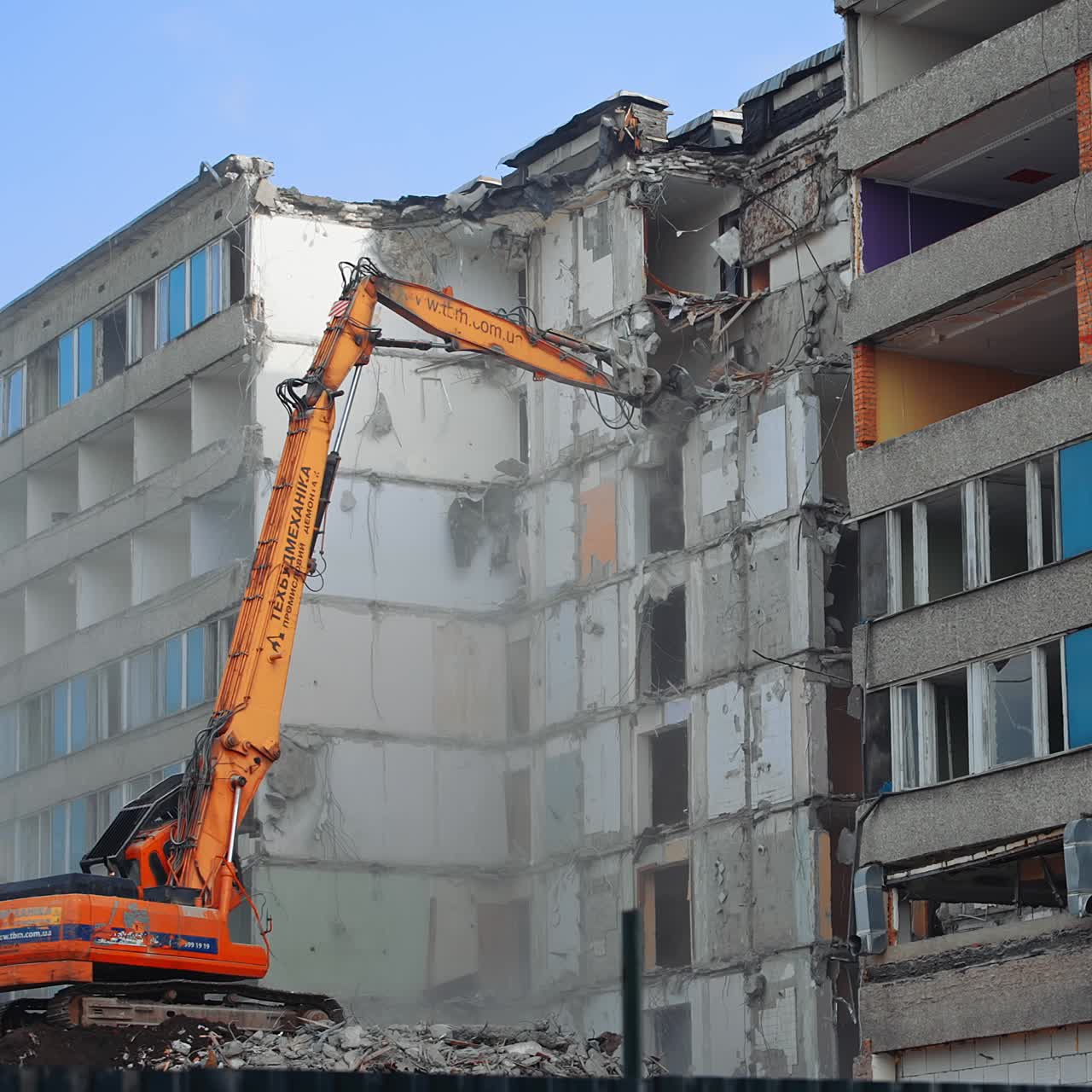 Demolition of the old multi flat house. House being demolished by special machinery
