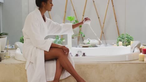 Mixed-race-woman-sitting-by-a-bathtub-at-home