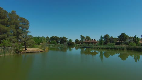 Niedriger-Flug-Mit-Hoher-Geschwindigkeit-über-Einen-Teich-Und-Einen-Park,-Der-Eine-Oase-In-Der-Wüste-Ist