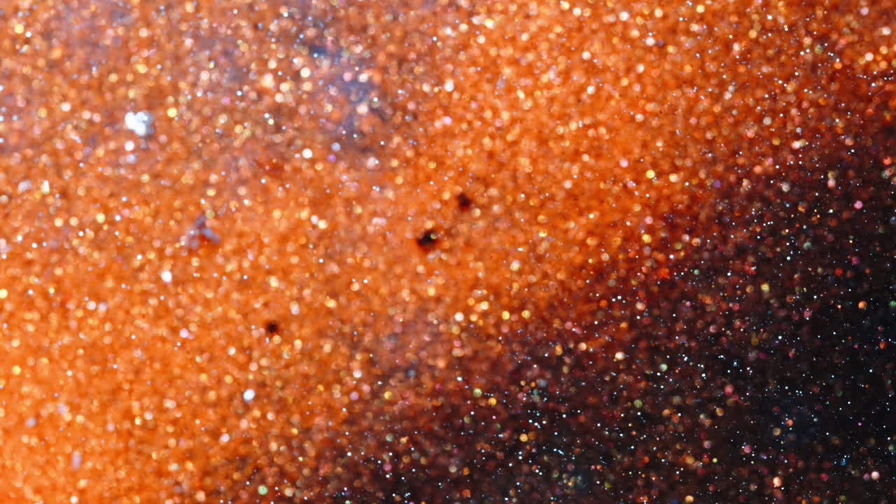 Vibrant ink mixes in a macro shot with shimmering texture detail