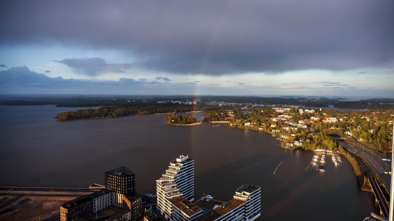 el lapso de tiempo de las nubes en movimiento y un arco iris sobre la isla de kulosaari en helsinki