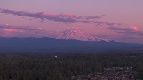 drone shot over bonney lake, washington of mount rainier during a pink sunset