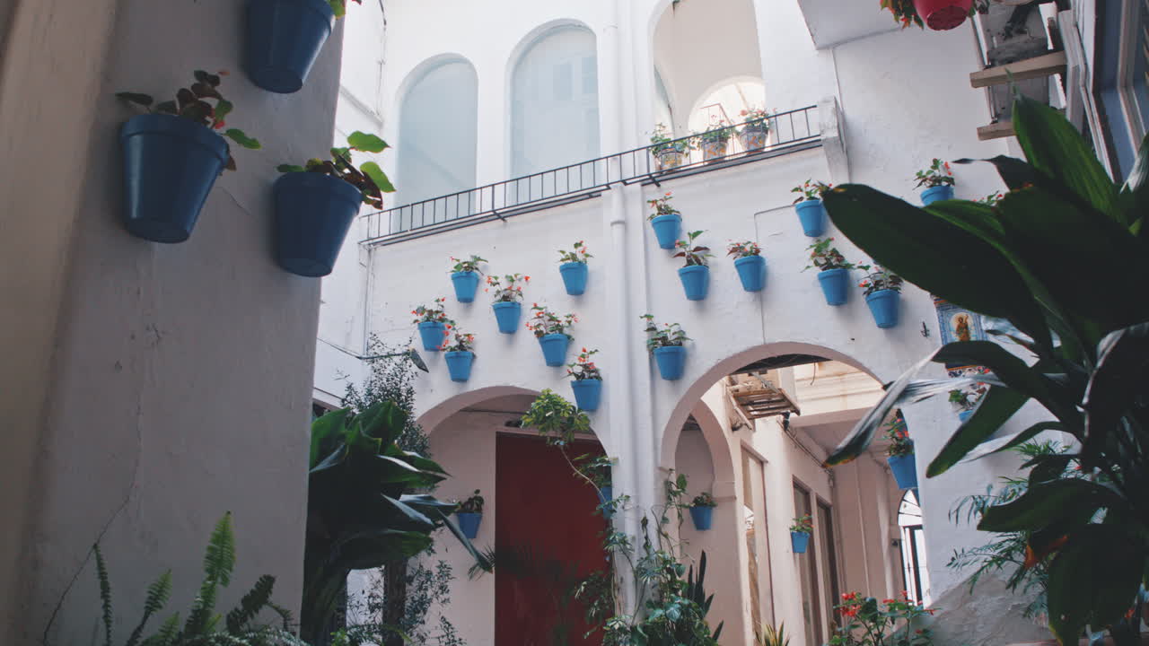 4K Marbella traditional white street and flowers in blue pots, Andalusia