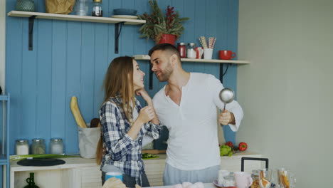 couple having fun in the kitchen preparing breakfast