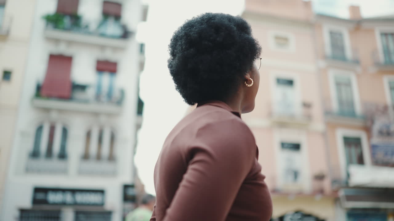 Tracking shot of attractive Afro girl exploring new city