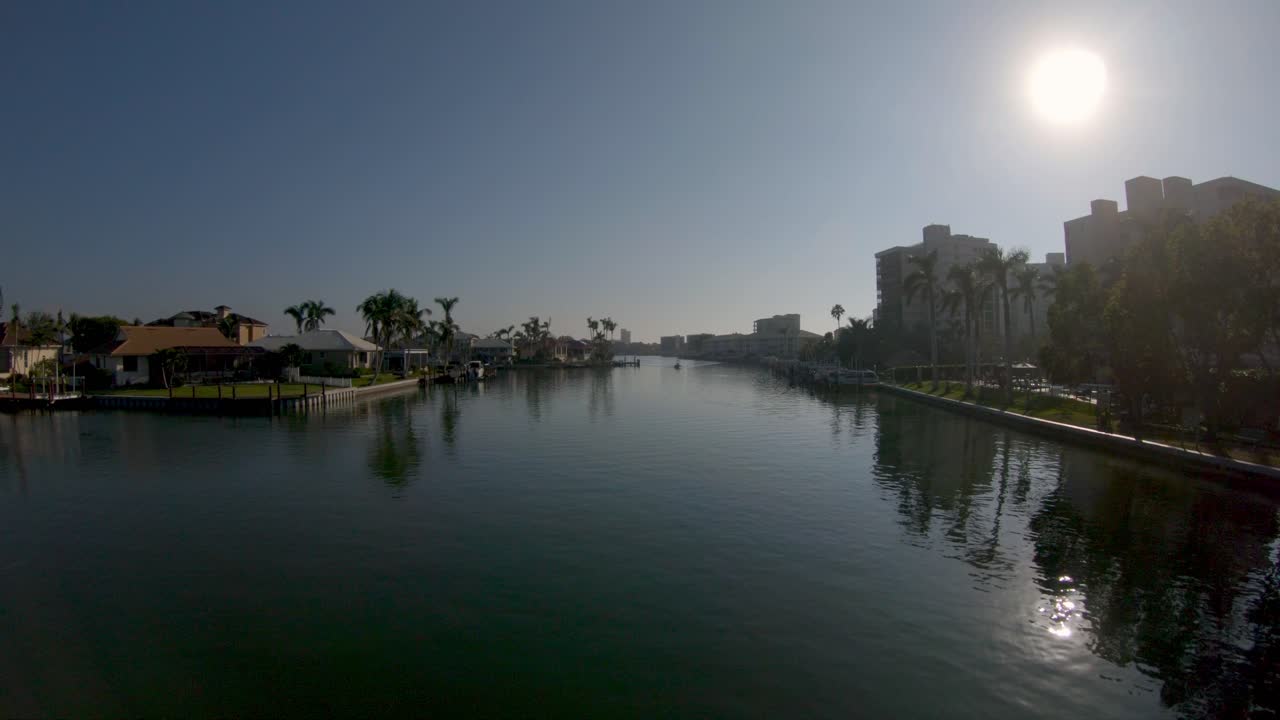 imágenes aéreas de drones 4k volando hacia atrás bajo a lo largo del río canal vanderbilt en nápoles, florida, ee.uu.