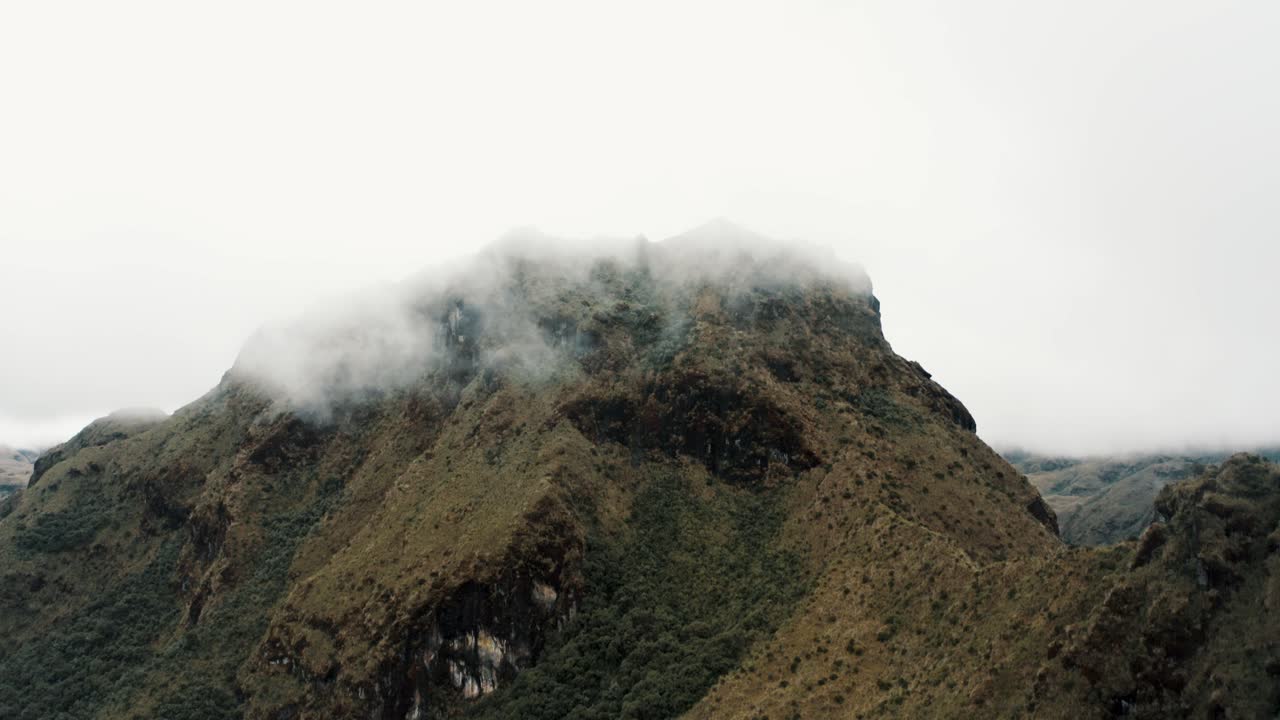 pico de la montaña envuelto por la niebla y las nubes temprano en la mañana en la reserva ecológica de cayambe coca en napo, ecuador
