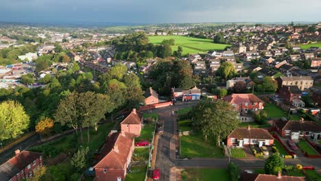 Britisches-Stadtbild:-Luftaufnahme-Der-Sozialwohnungen-Aus-Rotem-Backstein-In-Yorkshire,-Durchflutet-Von-Der-Morgensonne,-Mit-Häusern-Und-Menschen-Auf-Den-Straßen