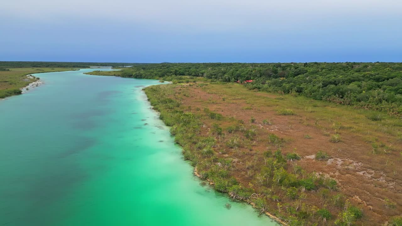 Serene aerial view of Bacalar's turquoise lagoon and lush shoreline
