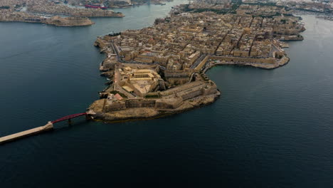 Aerial-tilt-shot-overlooking-the-Il-Belt-Valletta-bay,-cloudy-evening-in-Malta