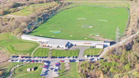 orbiting aerial of waterfront golf club driving range, rotherham, south yorkshire, uk, in summer morning light