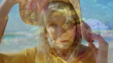 Composite-video-of-caucasian-senior-woman-wearing-a-hat-smiling-against-flower-in-the-garden