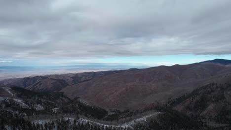 drone video high above the forest overlooking a valley with clouds