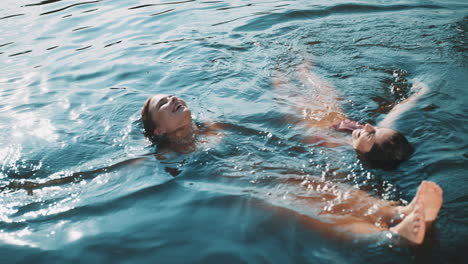 two women floating in a lake