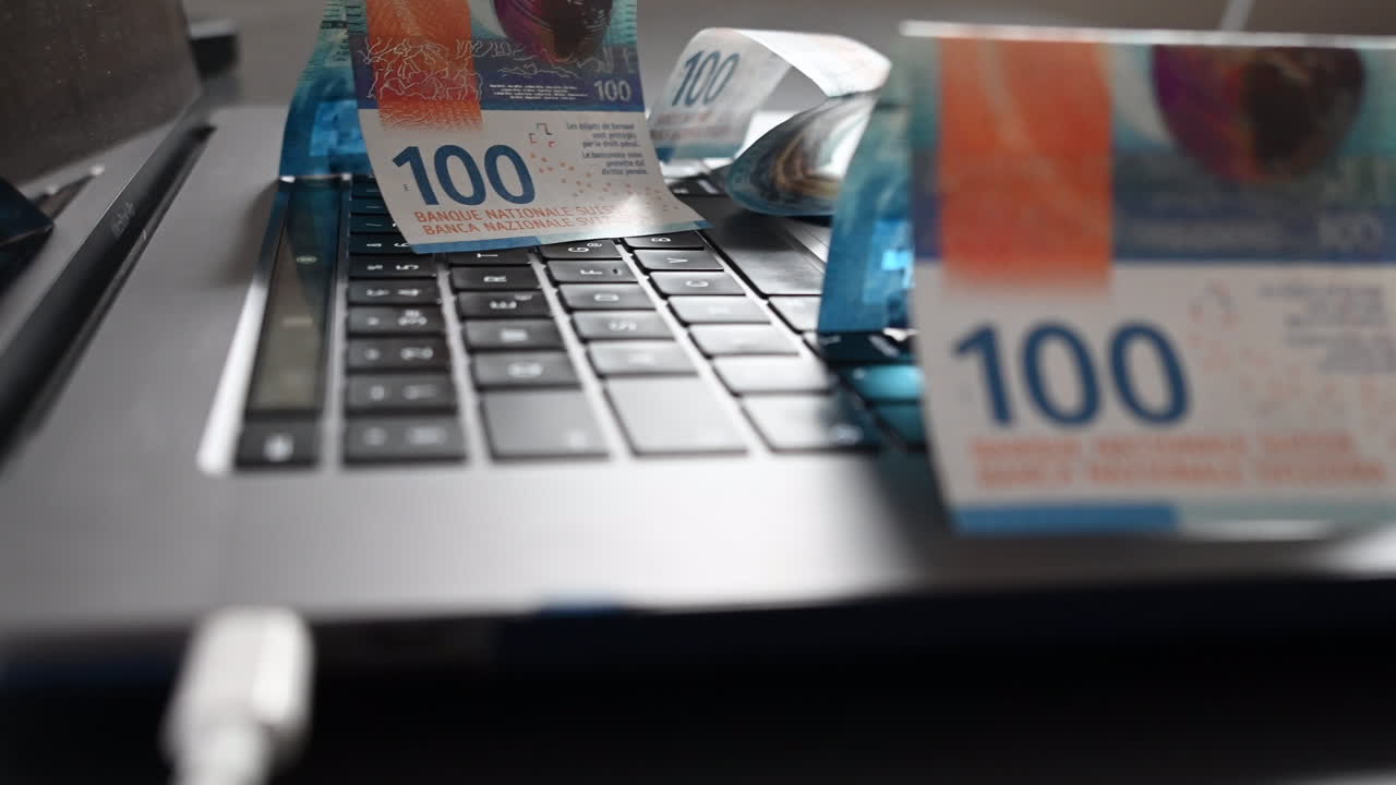 des billets de banque de 100 dollars reposent sur un clavier d'ordinateur portable, un flux de revenus en ligne réalisé sur internet