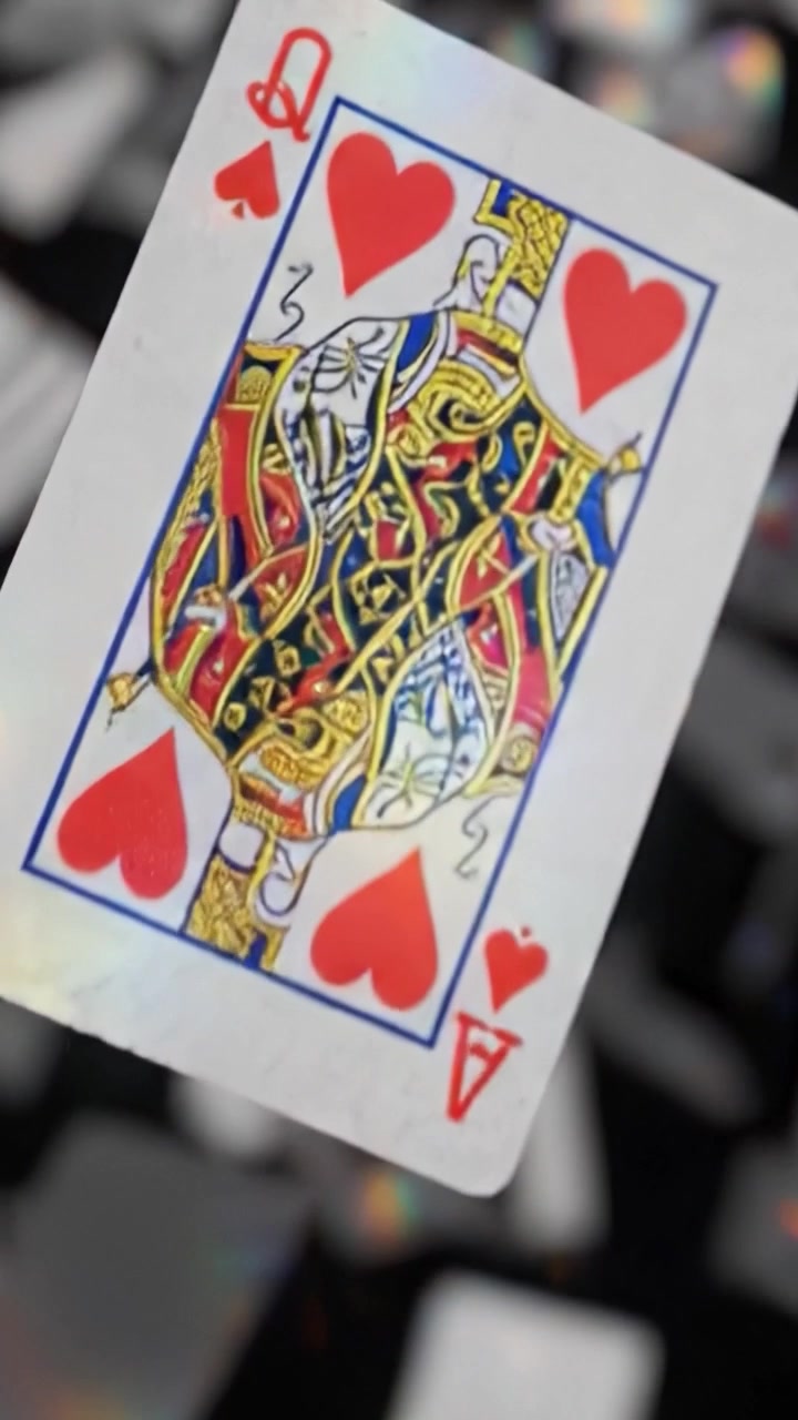 Un'abbagliante cascata di carte da gioco che si riversano nell'aria, catturando la luce e creando un affascinante svolazzare di movimento e colore su uno sfondo scuro.