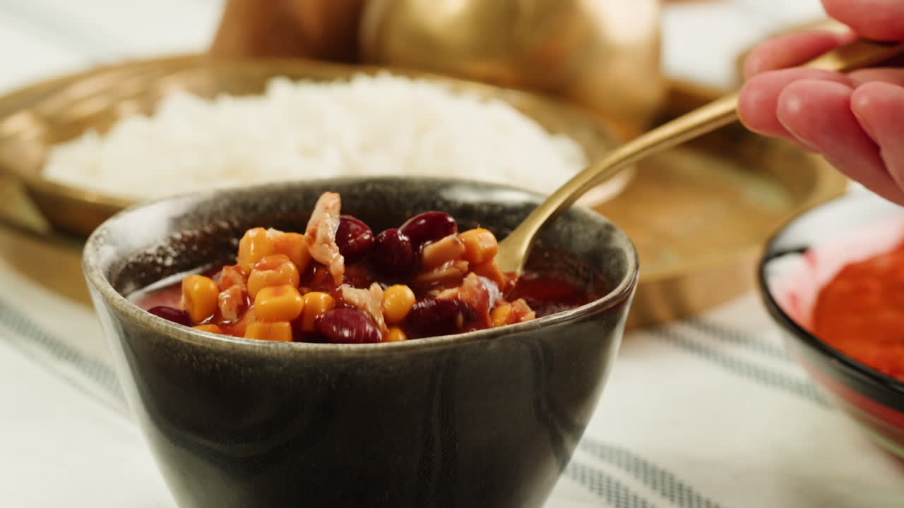 Indulge in a wholesome dinner with kidney beans, white rice, and a soothing soup in a warm and inviting atmosphere
