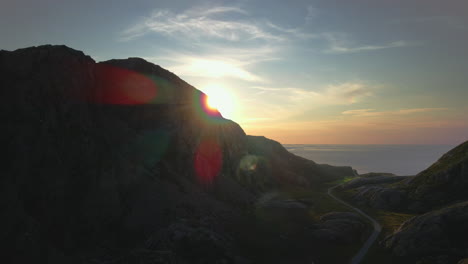 beautiful sunset hiding behind the mountains of heroy, norway -aerial descend