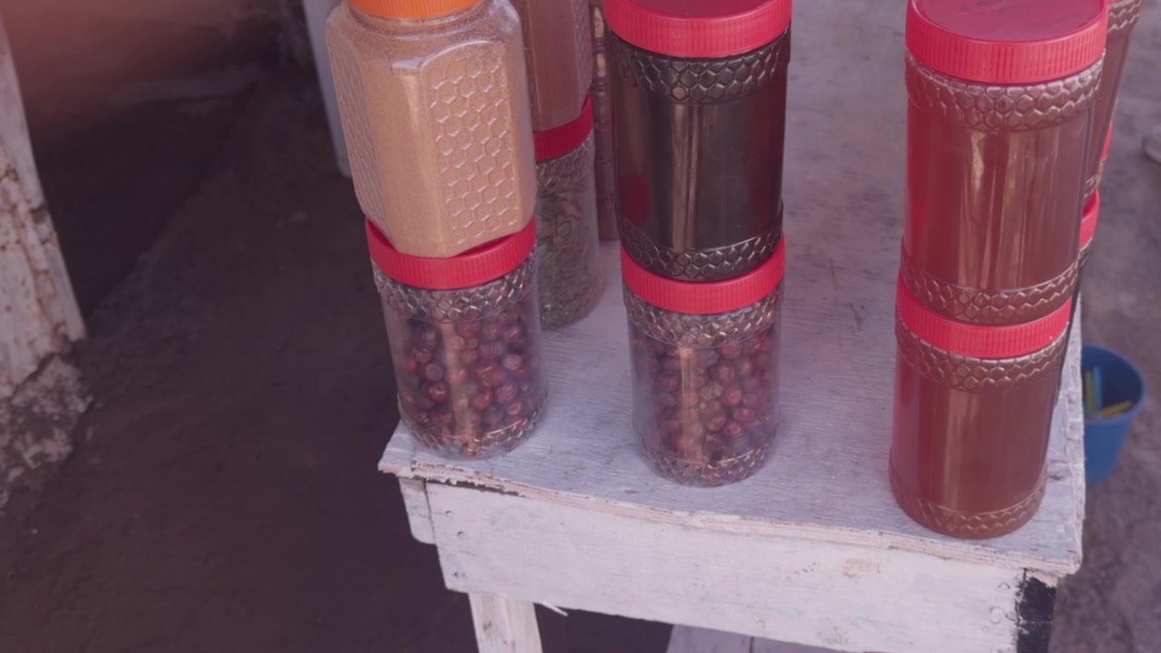 Amber honey jars and argan products stacked on white wooden table at Moroccan stall