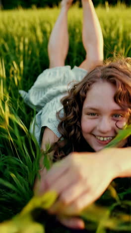joyful girl lying in a green field