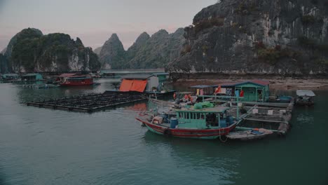 Aerial-Panning-shot-of-boats-parked-at-Lan-Ha-bay-in-Vietnam-during-sunset