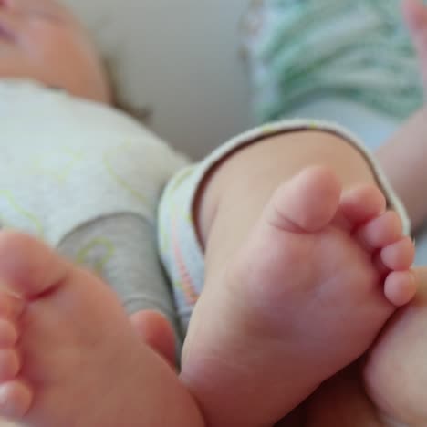 mother hold feets of newborn baby