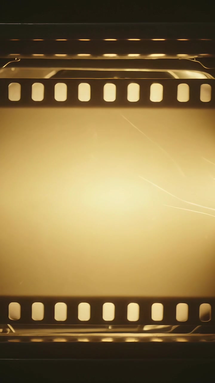 Vertical video: Lamp illuminating 35mm strip at gate, showing blank cell, scratches, sprocket holes