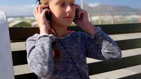 girl listening music on headphones at beach 4k