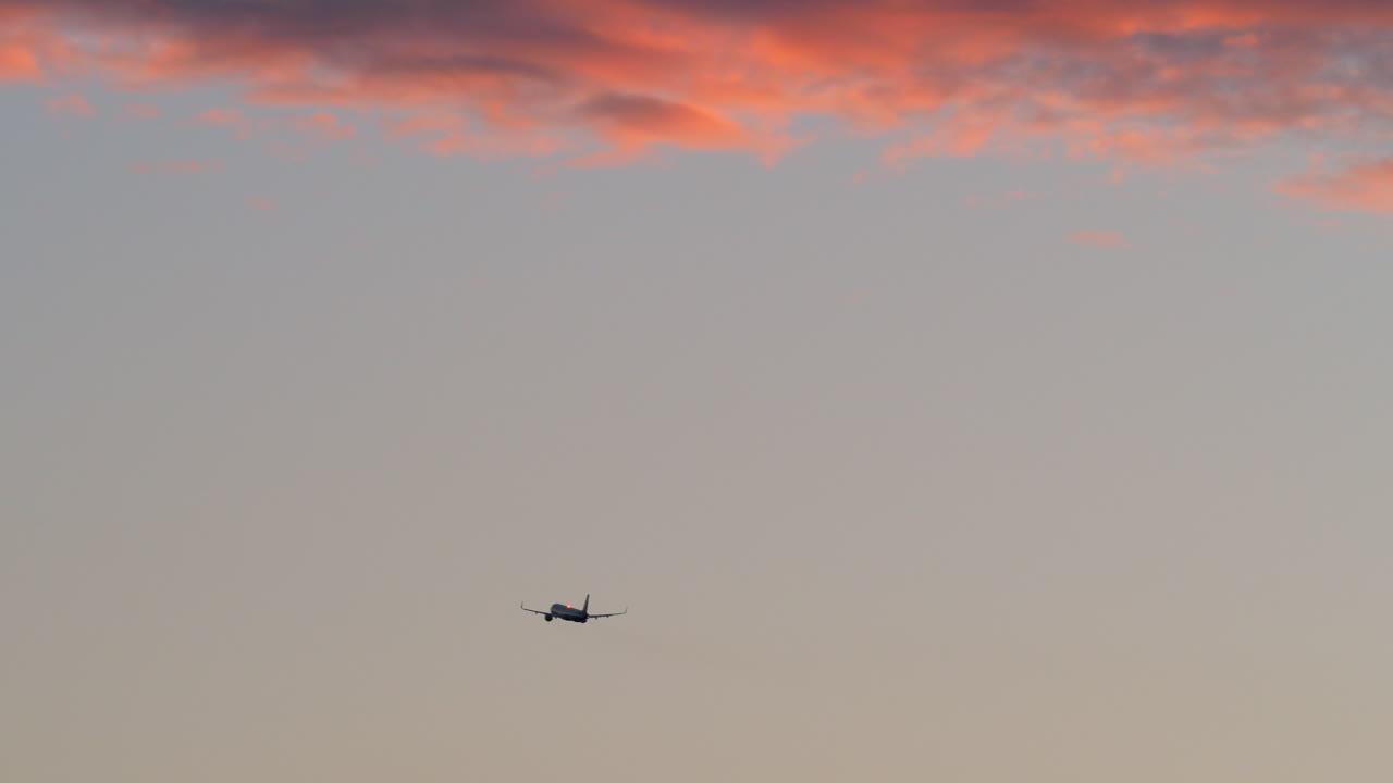 은 구름 을 가진 저녁 하늘 에서 날아다니는 비행기