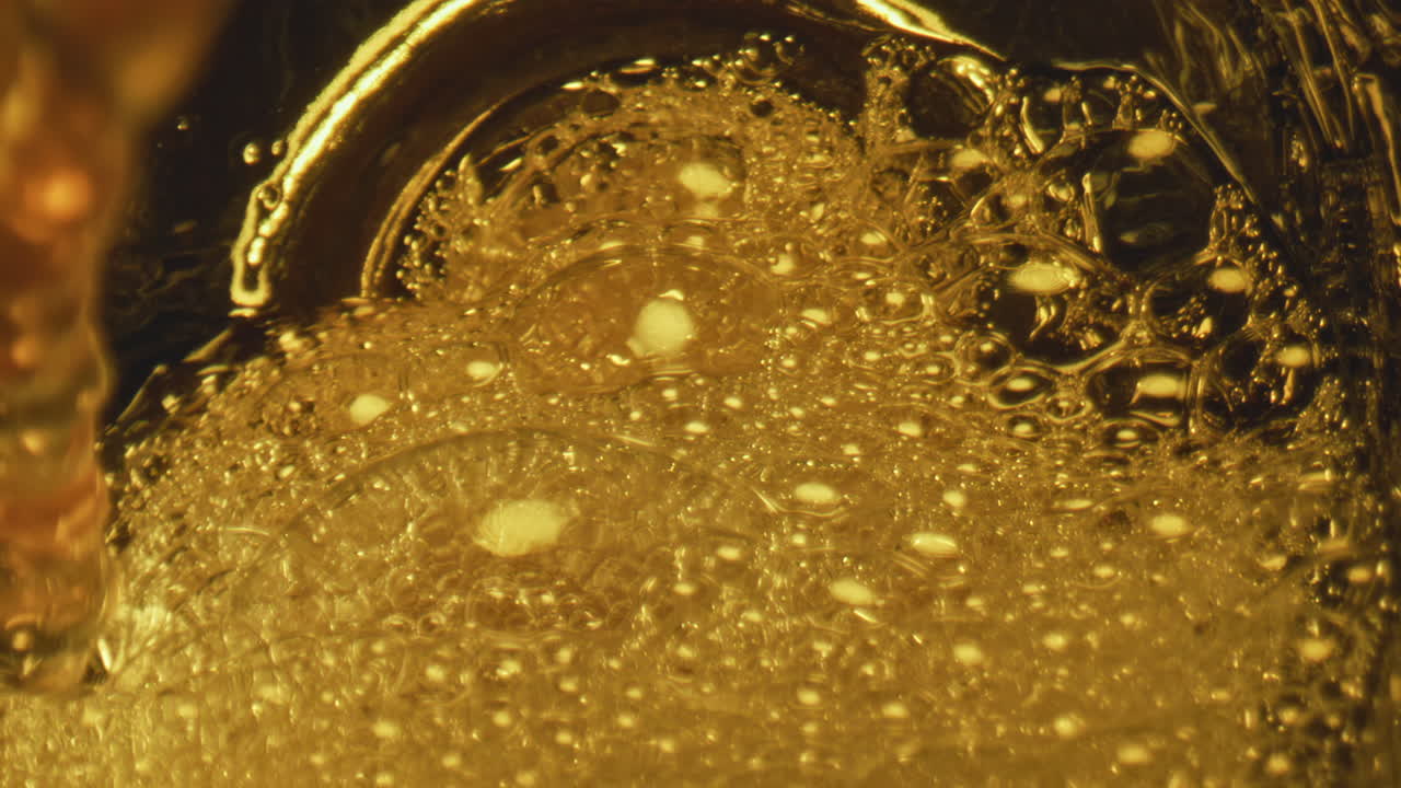 스포미 제트 (foamy jet) 가 유리 용품을 는 클로즈업 (close-up) 신선한 라거 맥주 (fresh lager beer) 가 는 컵 (bubbling goblet) 을 채운다.