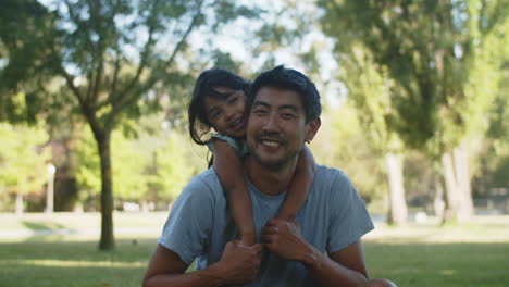 Retrato-De-Un-Hombre-Asiático-Feliz-Sentado-Con-Su-Pequeña-Hija