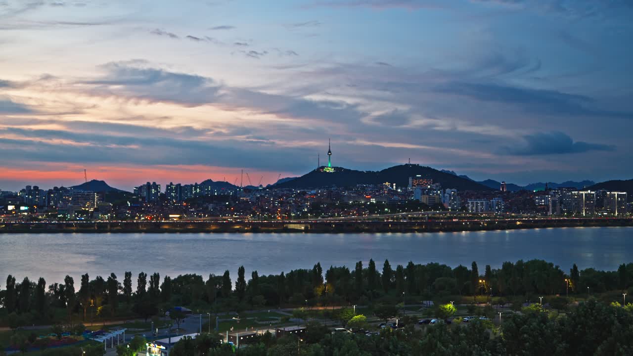 Static real-time aerial view of the iconic Namsan Tower and the Han River with city lights sparkling at sunset in Seoul South Korea