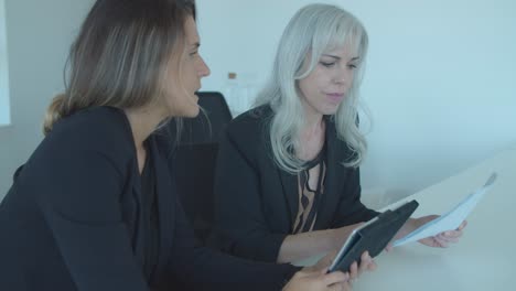 Friendly-female-colleagues-discussing-reports