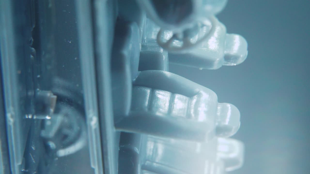 스튜디오 조명, 수직 매크로 클로즈업 샷, 4k 비디오, 은색 휠, 검은색 타이어, 문 및 창문, 플라스틱 시트가 있는 회전 스탠드에 있는 자동차의 작은 모델 금속 샘플 뼈대