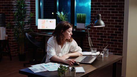 businesswoman working overtime for company project, doing tasks in office